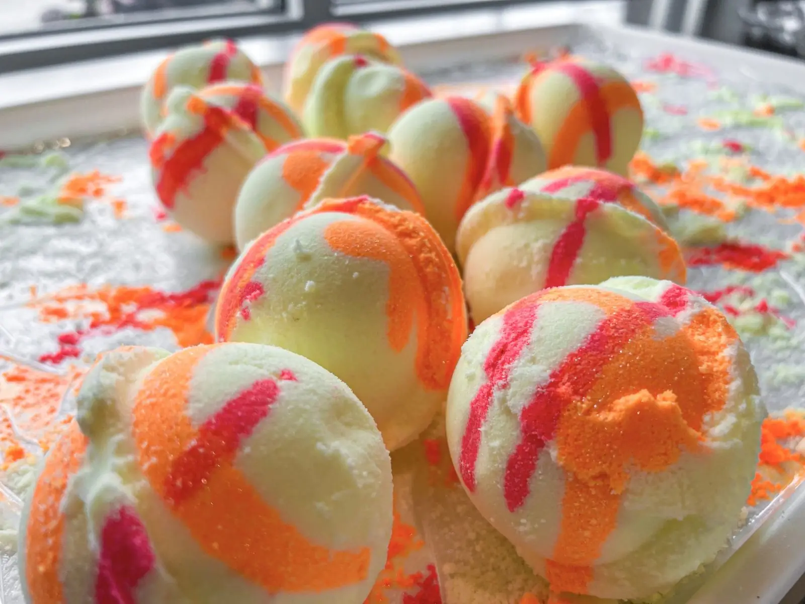 Handmade bath bombs swirled with orange and pink