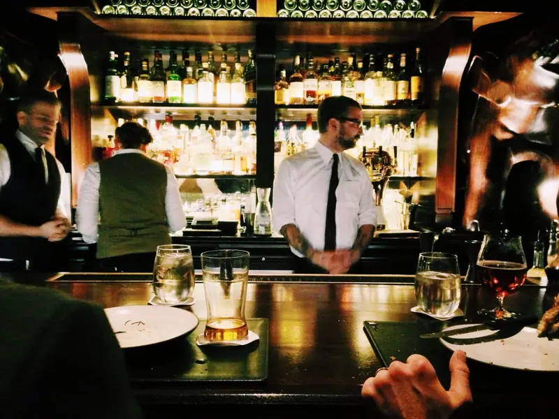 Bartendere i gang bag en velassorteret bar