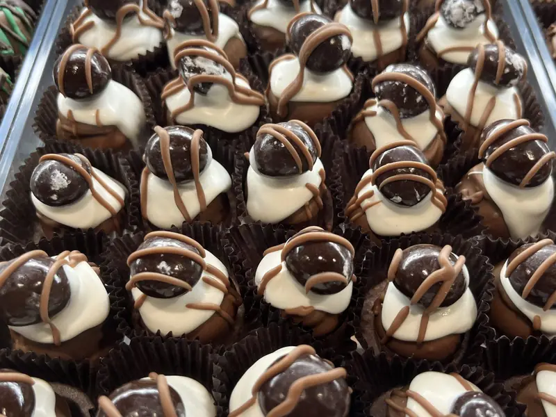 A tray of handmade chocolate truffles drizzled with chocolate