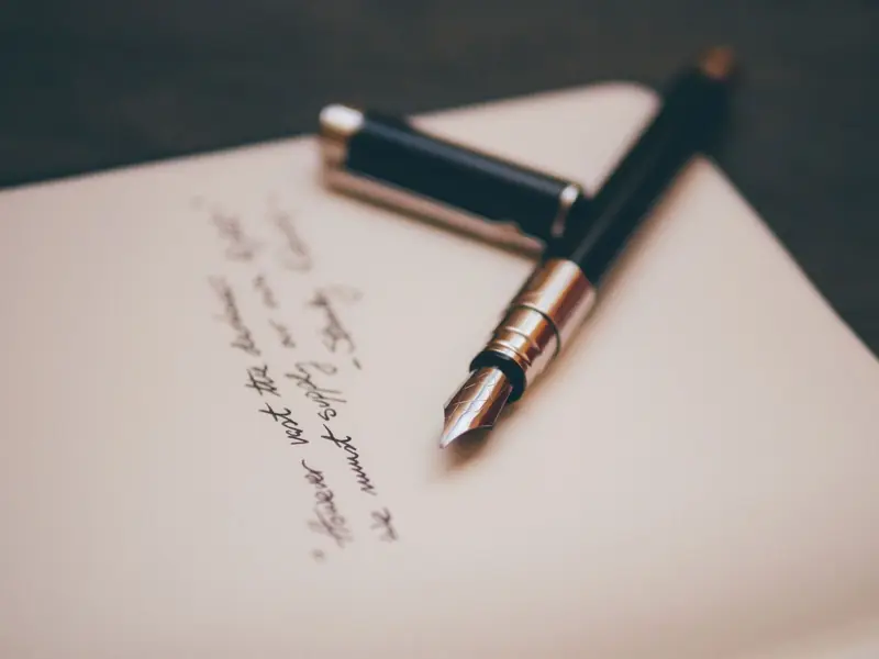 A fountain pen resting on a handwritten page